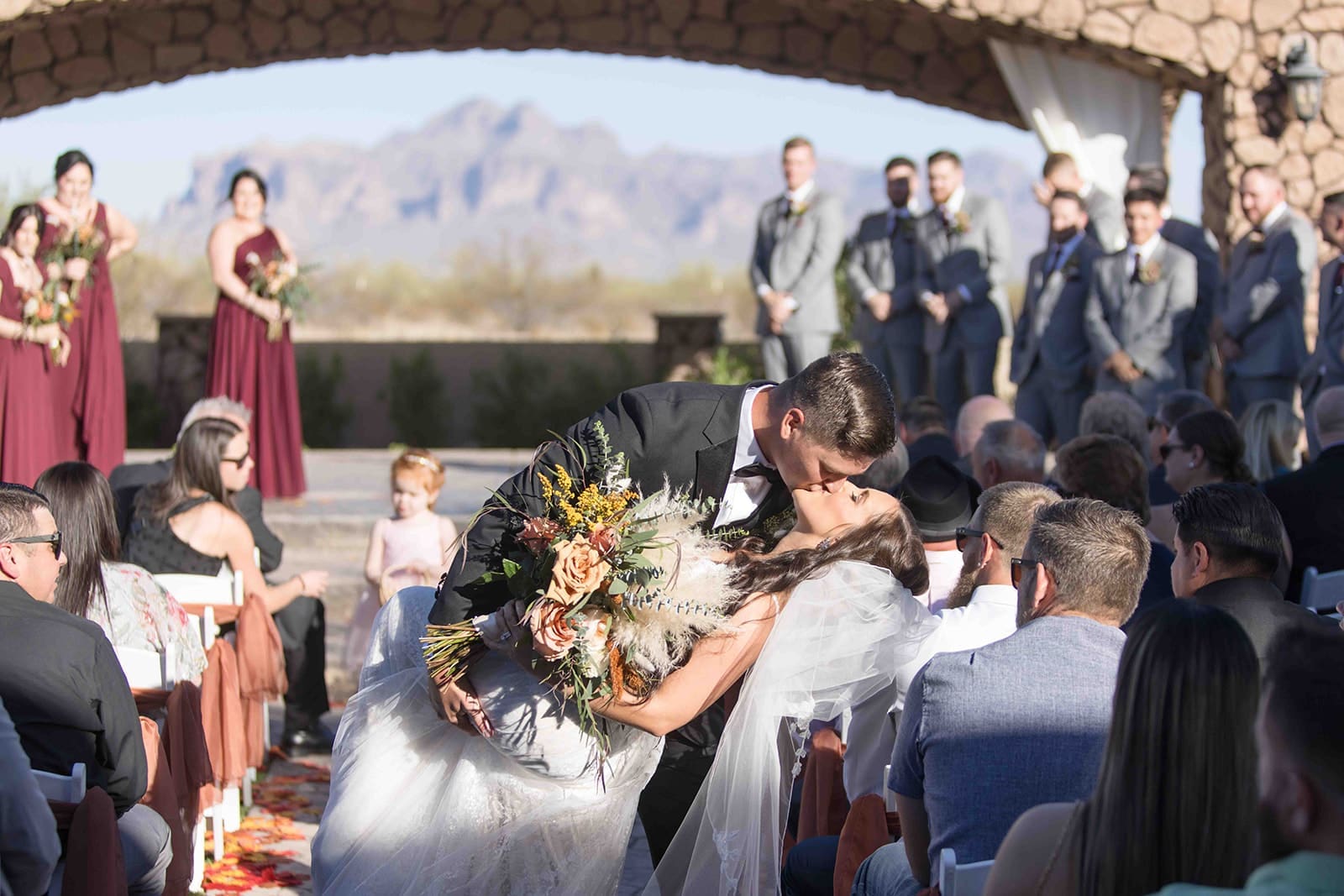 Bride and groom kiss down alter