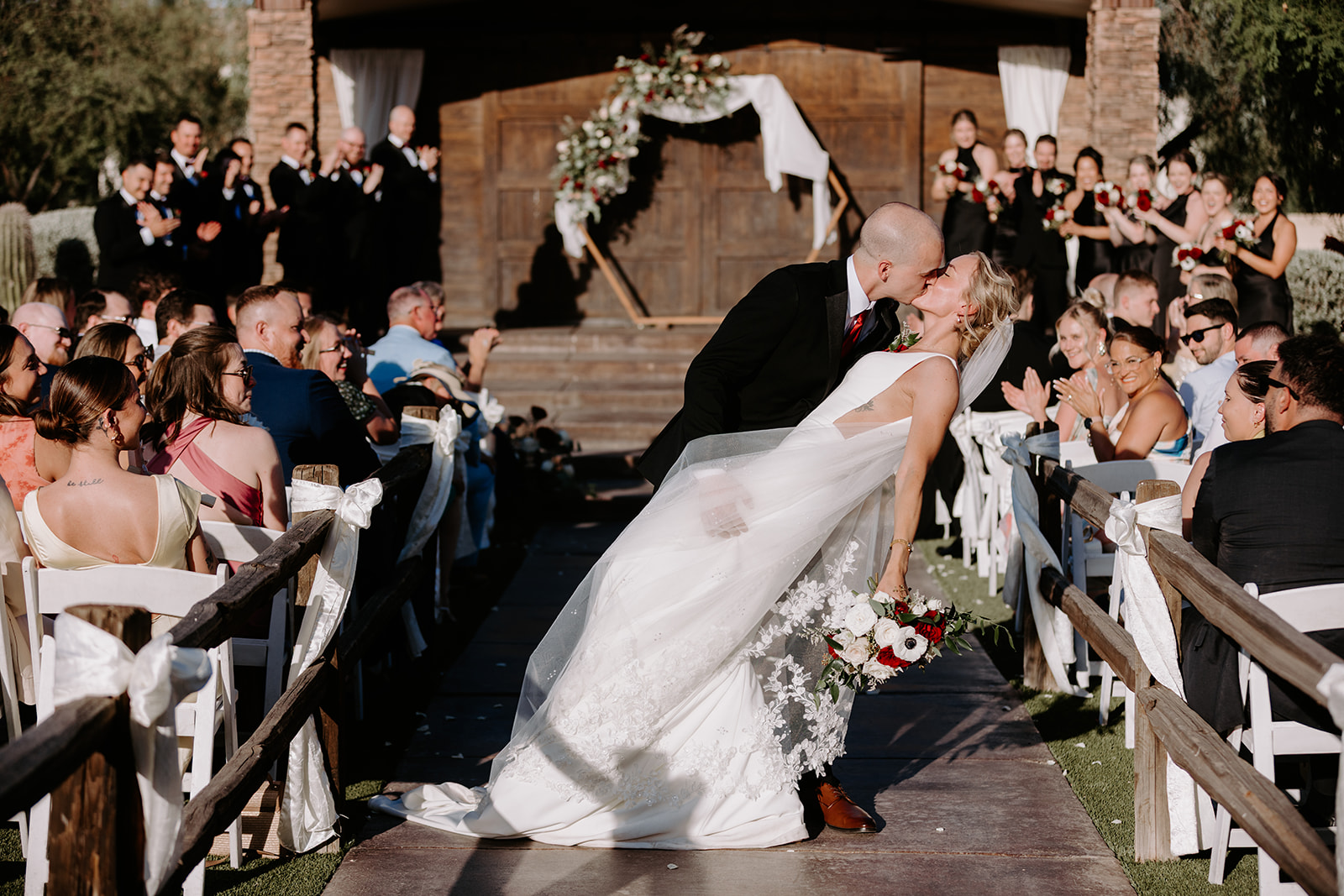 Bride and groom kiss down the isle